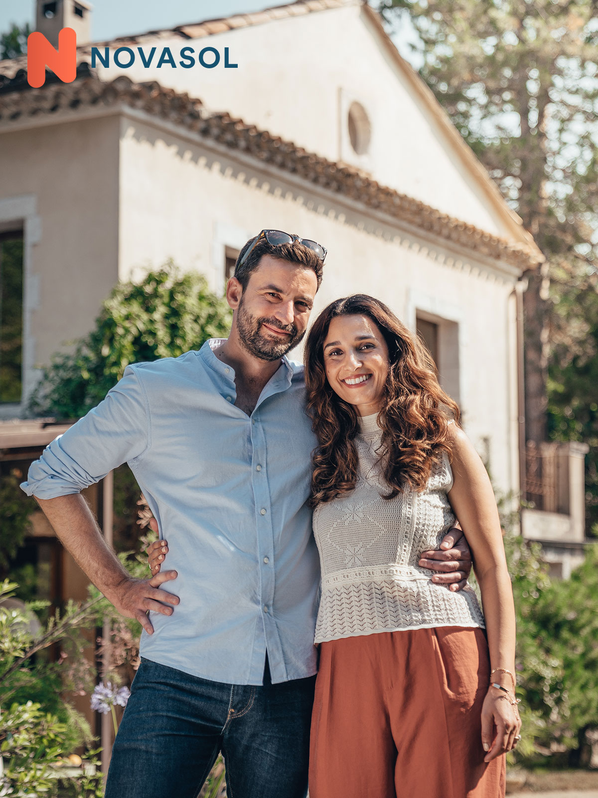 A couple standing in front of a house.